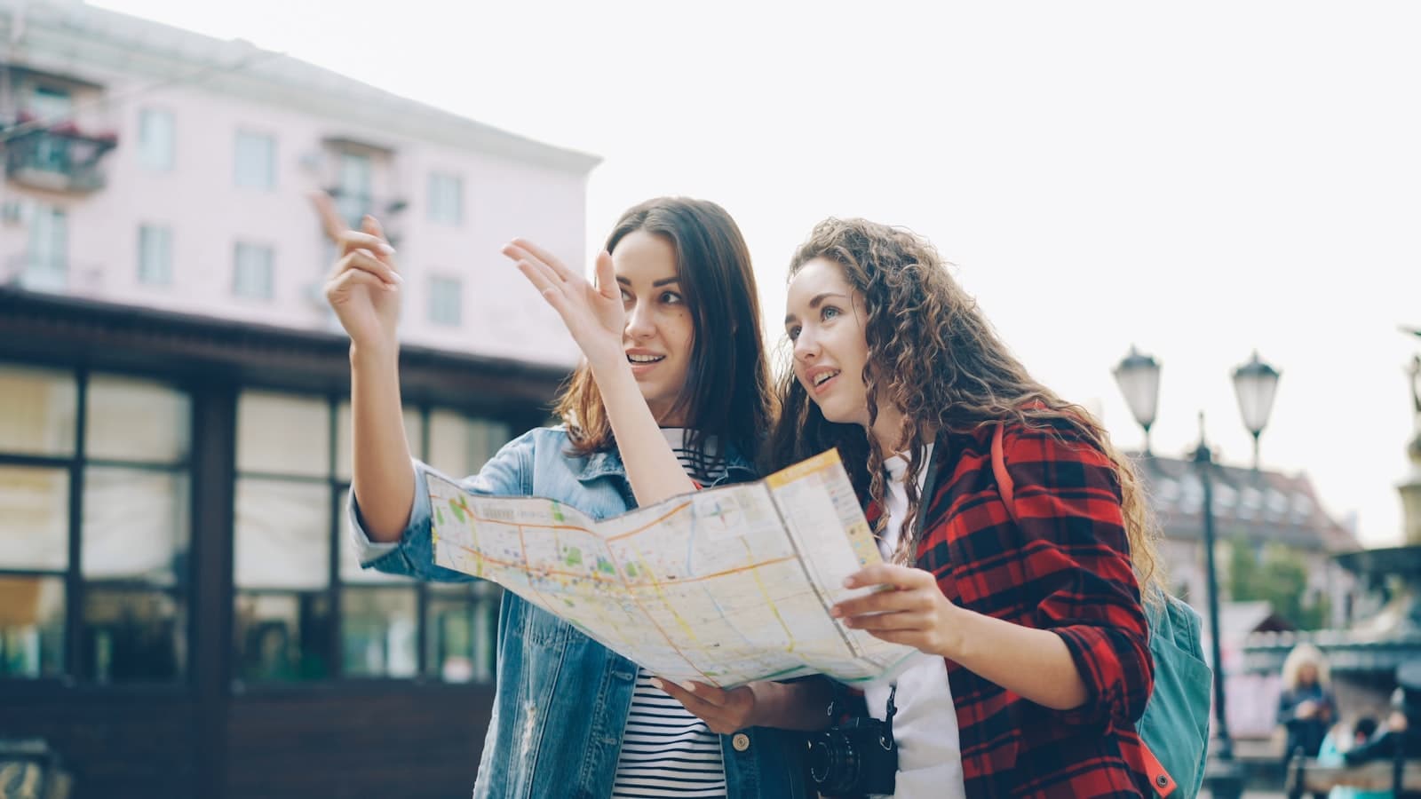 A traveler and local companion checking a map together on a city street